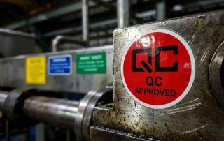 Rode circulaire inspectiesticker op industriële metalen apparatuur met andere gekleurde labels op achtergrond