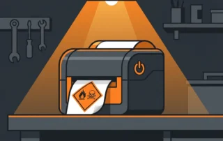 GHS-gevaarslabel met vlam- en doodshoofdpictogram in oranje en zwart, vers geprint op polyester vinyl door industriële labelprinter.